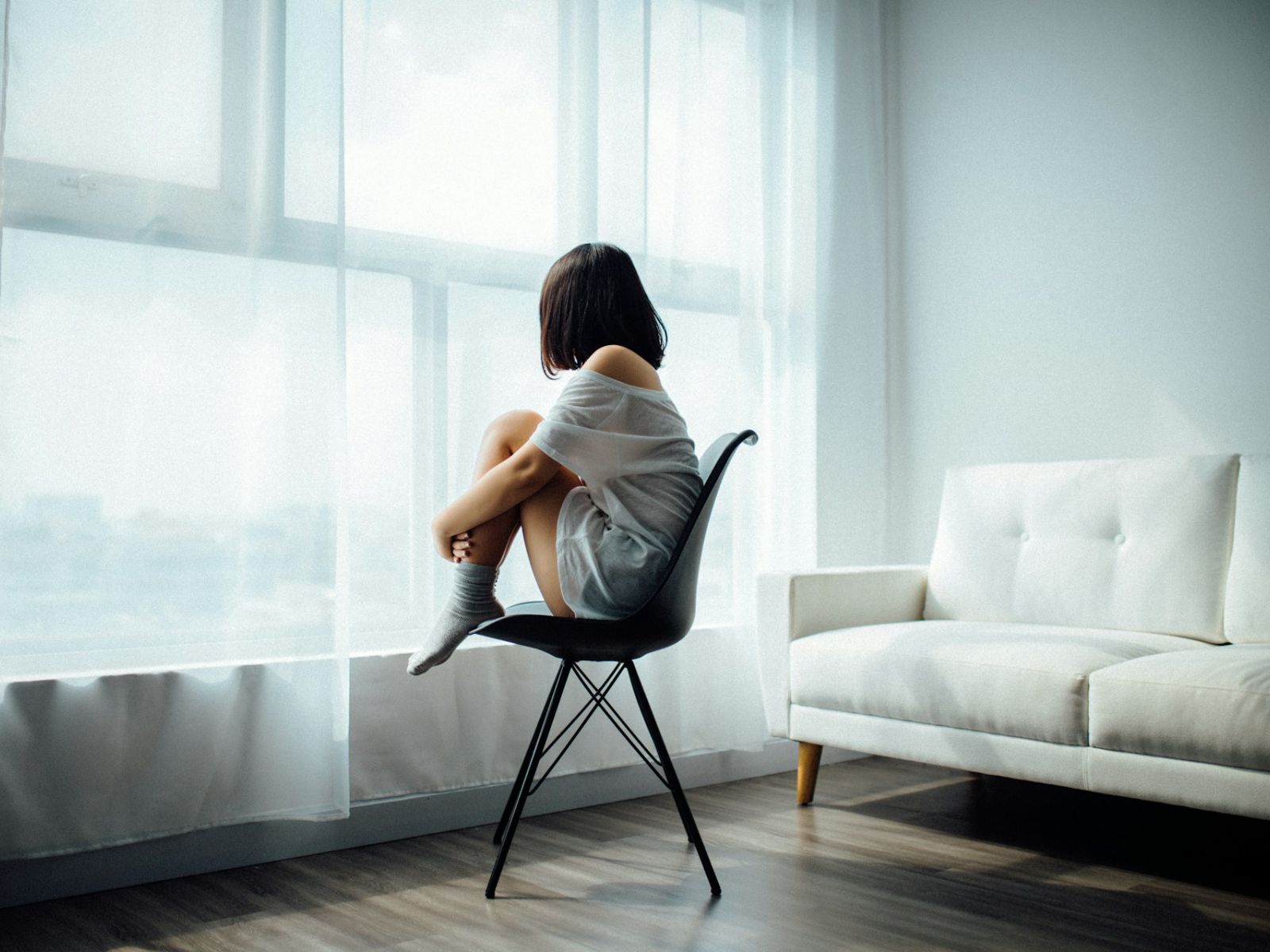 Therapy. Woman sitting on chair in room alone.