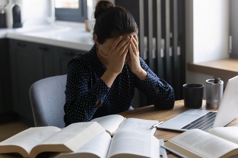 Mental Health Challenges. Tired Young Lady Sit At Home Desk Crowded.