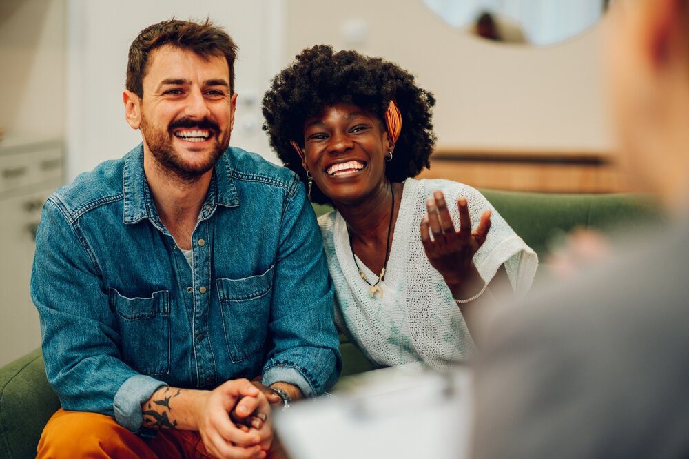 Couples Therapy. Interracial Couple in a session. Smiling.