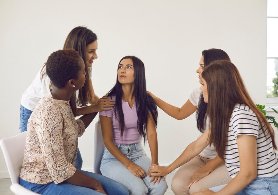 Self-Esteem Support. Multiracial Friends Talking To Young Girl And Giving Her Self Esteem support.